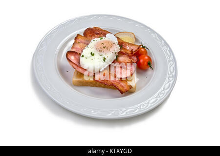 Pochiertes Ei auf weißen Toast mit Speck und Tomaten Stockfoto