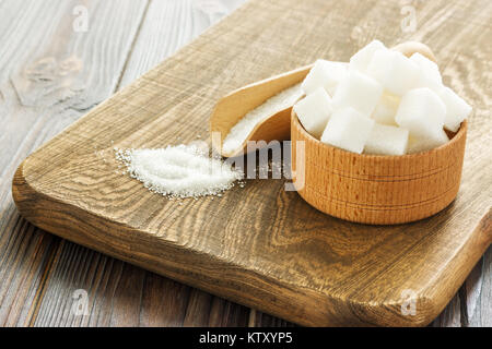 Holz- Schaufel und Schüssel mit Zucker auf Tisch, Nahaufnahme. Stockfoto