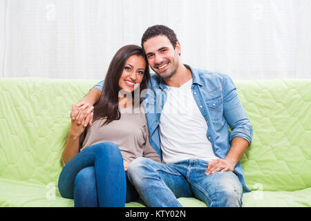 Glückliches Paar auf dem Sofa zu Hause sitzen. Stockfoto
