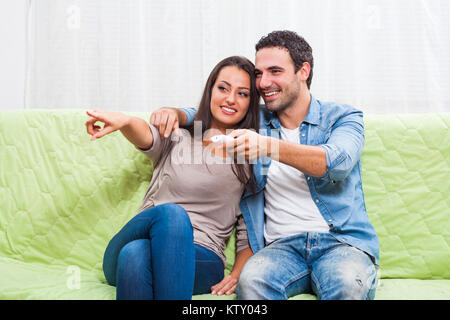 Glückliches Paar auf dem Sofa zu Hause sitzen und Fernsehen. Stockfoto