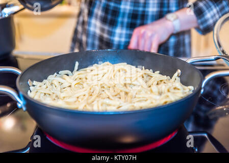 Hausgemachte Nudeln im Pan auf modernen Elektroherd. Stockfoto