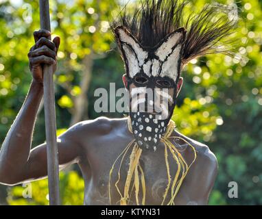 YOUW DORF, ASMAT REGION, Neuguinea, Indonesien - 23. MAI 2016: Kanu Krieg Zeremonie der Asmat Menschen. Headhunter eines Stammes von Asmat in einer Maske mit einem Stockfoto