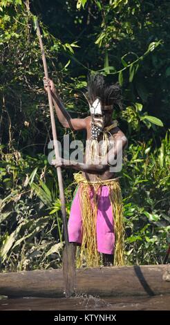 YOUW DORF, ASMAT REGION, Neuguinea, Indonesien - 23. MAI 2016: Kanu Krieg Zeremonie der Asmat Menschen. Headhunter eines Stammes von Asmat in einer Maske mit einem Stockfoto