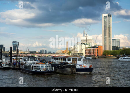 Boote auf der Themse mit South Bank Tower (von Richard Seifert) und Oxo Tower im Hintergrund und der Londoner City Skyline. London, Großbritannien Stockfoto