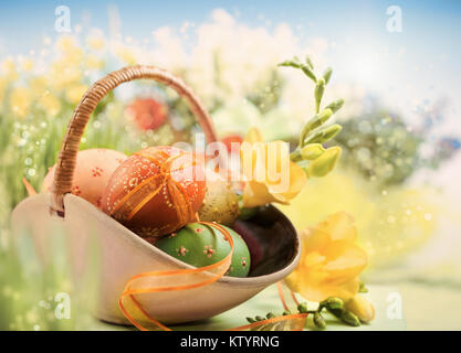 Ostern Hintergrund mit Eiern und Frühlingsblumen, flacher Freiheitsgrad, der vordere Ei mit der Multifunktionsleiste konzentrieren. Dieses Bild wird gestrafft. Stockfoto