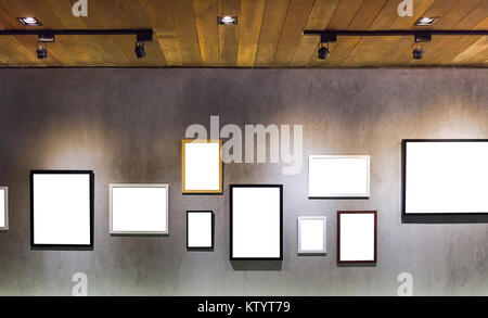 Leer leer Bilderrahmen hängen an ceent Wand mit Licht aus Holz Dach im Studio Stockfoto