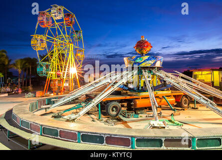 Riesenrad und die schwere Maschine in beweglichen Vergnügungspark bei Sonnenuntergang Zeit in Thailand. Stockfoto