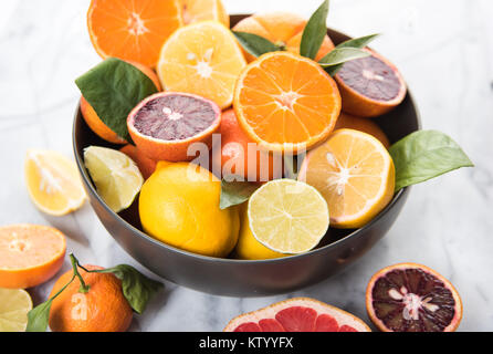 Frisches Blut Orangen, Limetten und Zitronen in Schale auf Marmor tisch Stockfoto