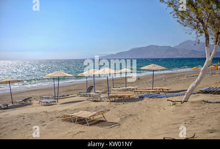 Liegen und Sonnenschirme am Strand von Kalamaki im südlichen Kreta Stockfoto