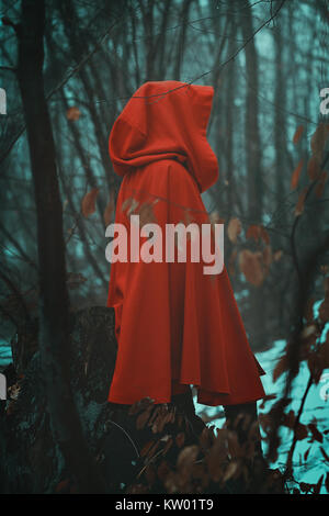 Geheimnisvolle rot vermummte Person in Misty woods Stockfoto