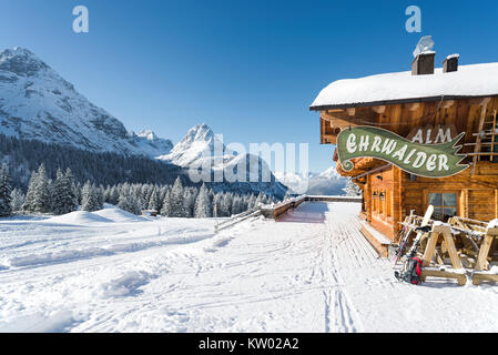 Alpine Chalet aus Holz auf der Ehrwalder Alm Skigebiet von einem sonnigen verschneiten Winterlandschaft umgeben, Tirol, Österreich Stockfoto