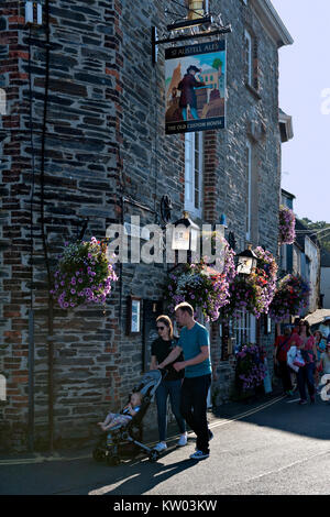 TA Paar treibt ein kleines Kind im Kinderwagen vorbei an der Old Custom House Public House in Padstow, Cornwall. Großbritannien Stockfoto