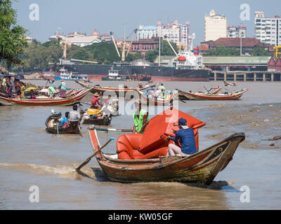 Lokale Fähren und Frachtschiffe auf Dala Fluss, wo es Yangon Fluss gelangt. Yangon Township sichtbar auf der gegenüberliegenden Seite von Yangon Fluss. Stockfoto