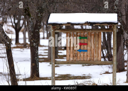Drei Pfeile, Blau, Rot und Grün auf Holz Tabellen über die richtige Richtung zu folgen. Verschneite Landschaft Stockfoto