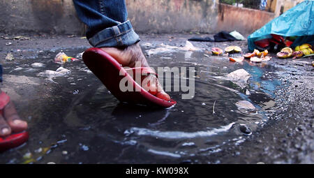 Junger Mann Spritzen in schmutziges Wasser in der Landschaft. Die Nahaufnahme Bein geschossen Stockfoto