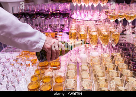 Gießen Champagner in Fancy Gläser. Barkeeper in Gläser gießen Champagner Stockfoto