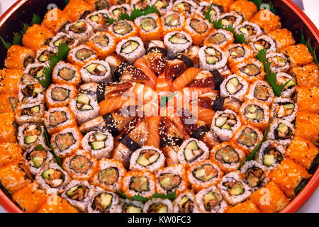 Verschiedene Arten von Sushi sind auf einem runden Teller eine Auswahl von japanischen Sushi Rollen gestapelt. Stockfoto