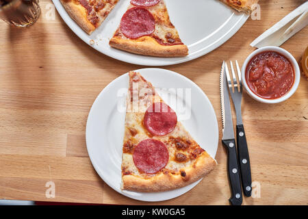 Frische Pizza mit Salami auf hölzernen Tisch im Restaurant. Stockfoto