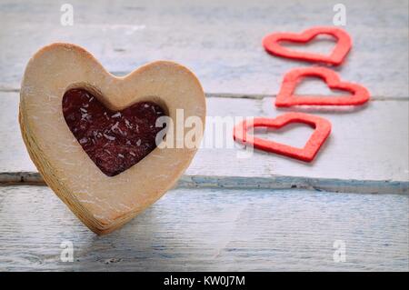 In der Nähe von Cookie mit Marmelade und drei rote Papier Herzen Stockfoto