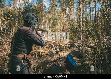 Nicht identifizierte Re-enactors gekleidet, wie Sowjetische Russische Rote Armee Infanterie Soldaten des Zweiten Weltkrieges versteckte Feuern auf Gegner im Frühjahr Wald am Historischen Re Stockfoto