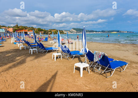 ZAKYNTHOS, Griechenland - 28. September 2017: Sonnenschirme und Liegen am Strand Argassi, eines der besten, schönen Sandstränden der Ostküste der Insel Isla Stockfoto