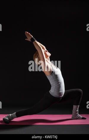 Junge Frau Üben Yoga, Virabhadrasana/Krieger darstellen Stockfoto
