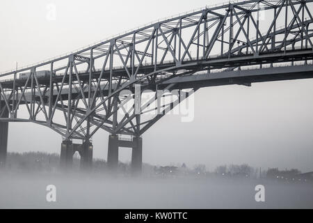 Die internationale Blue Water Bridge in dichtem Nebel mit Eisenbahnschienen im Vordergrund. Das blaue Wasser Brücken verbindet der USA und in Ontario, Kanada. Stockfoto