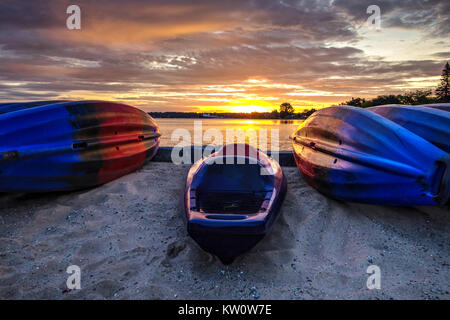 Kajak Sonnenaufgang. Kajaks am Strand bei Sonnenaufgang auf den Großen Seen Küste von downtown Traverse City, Michigan. Stockfoto