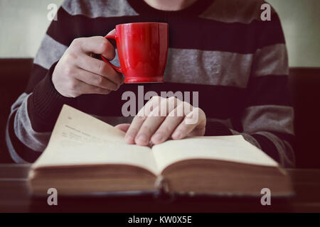 Business mann lesen Buch mit Kaffee im Café close-up. Seite drehen Stockfoto