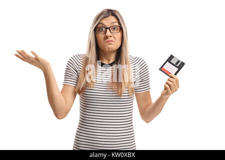 Verwirrte junge Frau mit einer Diskette auf weißem Hintergrund Stockfoto