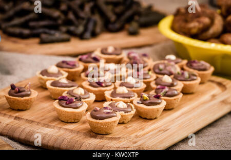 Schokolade Puddings innerhalb von Sweet cookie Schalen auf einem hölzernen service Fach Stockfoto