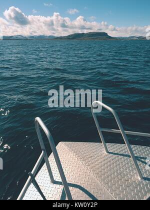 Angeln im Meer aus Stahl Fischerboot auf offenes Wasser. Rocky Island et Horizont. Kalten sonnigen Tag am Meer Stockfoto