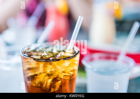 Makro Nahaufnahme von Eistee oder Cola mit Eiswürfeln und Stroh in Glas Stockfoto