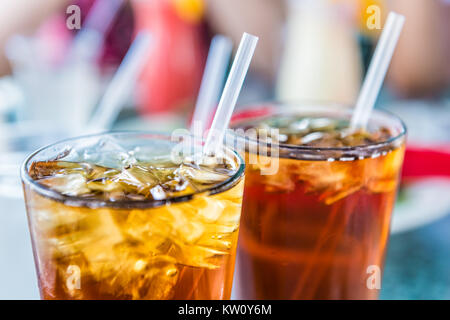 Makro Nahaufnahme von Eistee oder Cola mit Eiswürfeln und Stroh in Glas Stockfoto