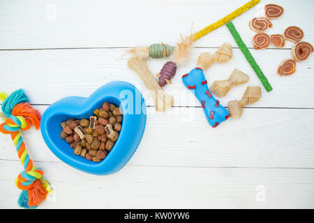 Pet care, Tierarzt, grooming Konzept. Nahrhafte Lebensmittel für Ihren Freund. Ich liebe Haustiere Inschrift aus Hund Spielzeug, Snacks und einer Schüssel trocken Hundefutter auf Stockfoto