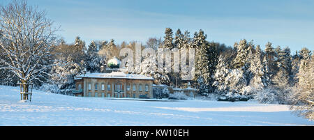 Sezincote-Haus und Winterbäume im Schnee. In der Nähe von Moreton-in-Marsh, Cotswolds, Gloucestershire, England. Panorama Stockfoto