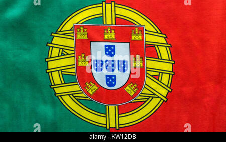 Ein portugiesischer Flagge wird dargestellt, wie es auf einer ebenen Fläche aufliegt. Die Wappen zwischen den kräftigen Farben Rot und Grün ist ein großes Symbol für die COUNTR Stockfoto