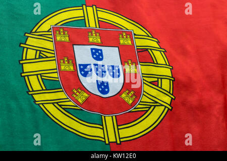 Ein portugiesischer Flagge wird dargestellt, wie es auf einer ebenen Fläche aufliegt. Die Wappen zwischen den kräftigen Farben Rot und Grün ist ein großes Symbol für die COUNTR Stockfoto