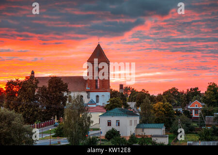 Mir, Belarus. Sonnenuntergang über Landschaft der Häuser des Dorfes und Saint Nicolas Römisch-katholische Kirche in Mir, Belarus. Das Wahrzeichen der Stadt. Historische Arc Stockfoto