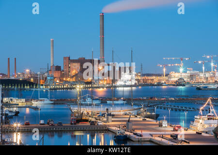 Helsinki, Finnland. Abend Nacht Industriegebiet von hanasaari Kraftwerk und Pier, Liegeplatz mit angelegten Schiffe, Schiffe. Nacht Illuminationen Ligh Stockfoto