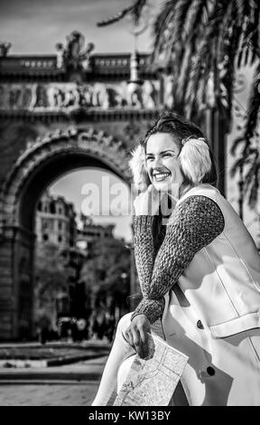 in Barcelona für einen perfekten Winter. glückliche trendige Frau in Ohrenschützer in Barcelona, Spanien mit Karte Stockfoto