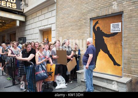 Bevor eine Leistung der Broadway Musical Hamilton zwei Tage vor dem Schöpfer Lin Manuel Miranda's Abfahrt von der Show, ein Wachmann steht als Fans an der Stage Door holding Merchandise und hausgemachte Zeichen sammeln, New York City, New York, 7. Juli 2016. Stockfoto