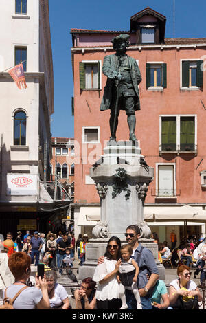 Eine junge Familie vor der Statue des berühmten venezianischen playright Carlo Goldoni, Venedig posing Stockfoto