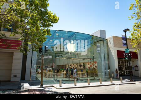 An einem sonnigen Tag, ein Mann hinter dem Eingang zum Flaggschiff elektronik Apple Store auf der University Avenue in der Innenstadt von Palo Alto, Kalifornien, 2016. Stockfoto