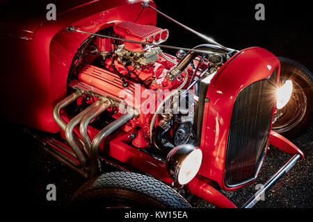 Auf Schwarz, Rot Ford Hot Rod Engine zeigt die Details der Kopfzeilen, Rohre und vier Zylinder Vergaser isoliert, in der Nacht mit Licht malen erschossen. Stockfoto