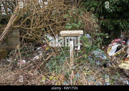 Von einer Zuteilung Zeichen in einem wirklich unordentlichen Schrebergarten überwachsen Schuttplatz müll Sauerei schließen. tote Gras, Stroh, Heu, Holz, abgestorbene Pflanzen. Stockfoto