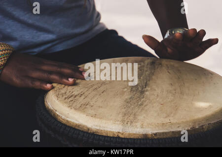 In der Nähe der Hände einer Frau Spielen eines Drum. Die Hände der schwarzen Frauen aus Nigeria das Schlagen der Trommel Stockfoto