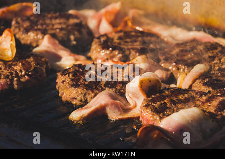 Schnitzel Hackfleisch Burger gebratenem und gegrilltem Speck. Herstellung von Zutaten für einen Hamburger. Flammende Grill- und Rindfleisch Burger. Fleisch hamburger Patty cl Stockfoto
