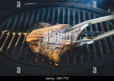 Gestreifte Steak auf dem Fiery Grill closeup. großes Stück vom Lamm Straße auf dem Grill mit gebratenen Streifen Stockfoto