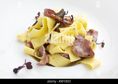 Pasta Carbonara mit Speck auf weißem Hintergrund Stockfoto